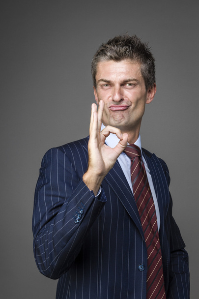 Элегантный довольный бизнесмен в порядке жеста
 - Фото, изображение