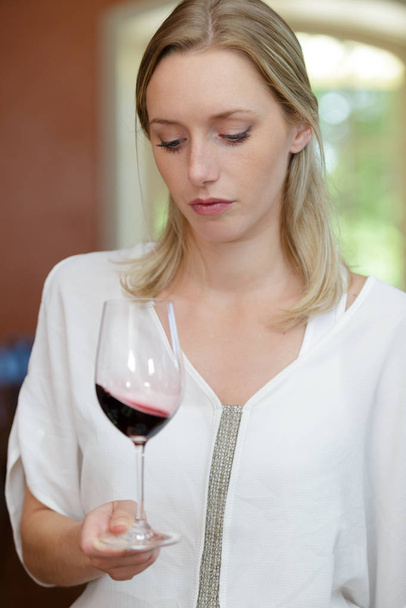 žena hledící na víno ve sklenici - Fotografie, Obrázek