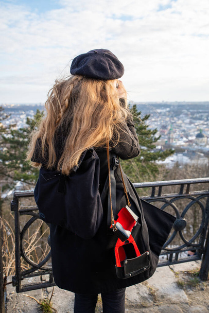 woman in black beret and winter coat taking picture of panoramic city view - Photo, Image
