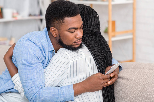 Csaló férj sms-ezik valakivel mobilon, miközben megöleli a feleségét - Fotó, kép