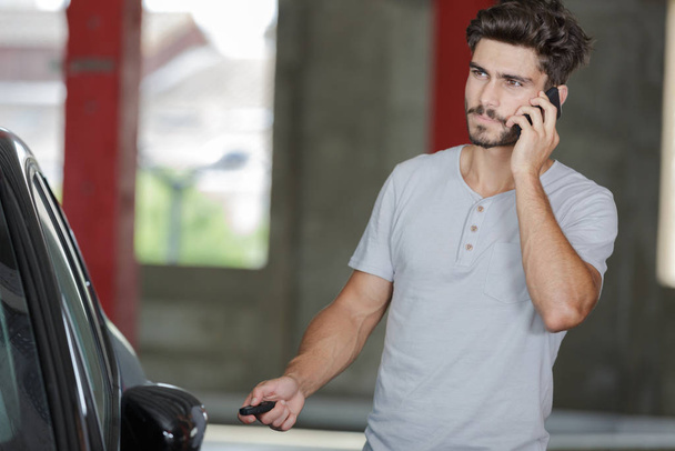young man on the phone next to car - Photo, image