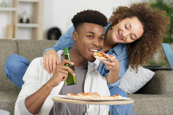 happy young couple preparing pizza in their home - Foto, imagen