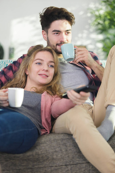 couple chilling on the sofa sipping beverage - 写真・画像