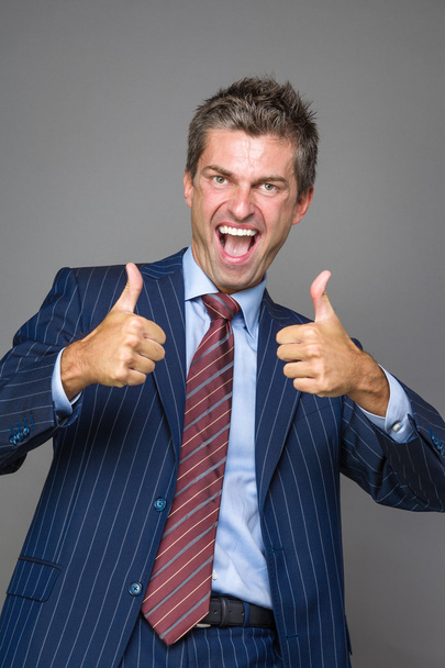 Happy businessman in thumbs up gesture - Photo, Image