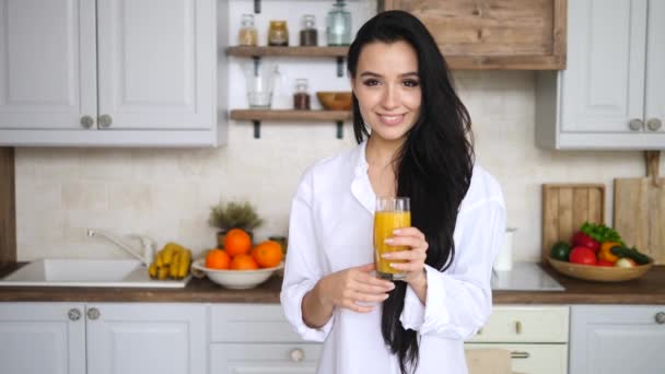 Young Female With Orange Juice On Kitchen At Home. Healthy Diet Concept. - Materiał filmowy, wideo