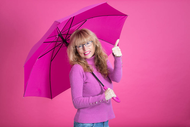 женщина машет с открытым зонтом на цветном фоне
 - Фото, изображение