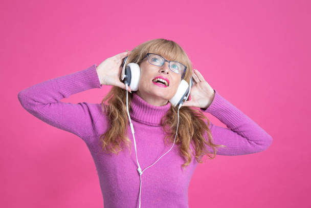 доросла жінка з танцями і прослуховуванням музики з навушниками
 - Фото, зображення
