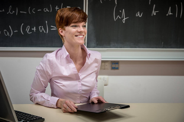 Giovane insegnante lezioni presso la Scuola di Matematica, scrive gesso su una lavagna
 - Foto, immagini