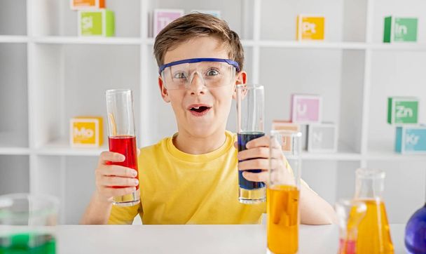 Astonished little chemist studying at school - Foto, Imagem
