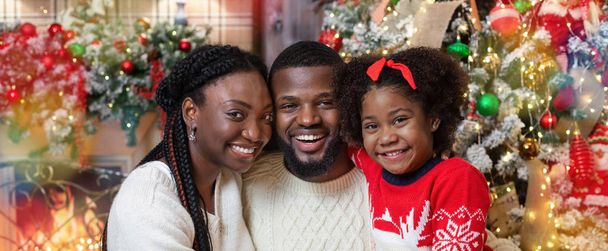 Cheerful african family posing together near Xmas tree at home - Fotografie, Obrázek