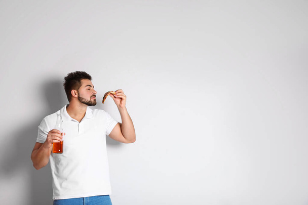 Όμορφος άντρας με πίτσα και μπύρα σε λευκό φόντο, χώρος για κείμενο - Φωτογραφία, εικόνα