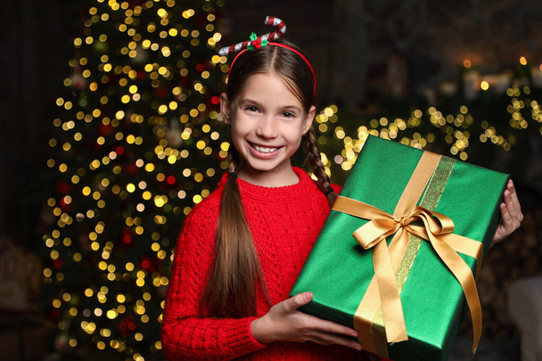 Portret szczęśliwego dziecka z prezentem świątecznym w domu - Zdjęcie, obraz