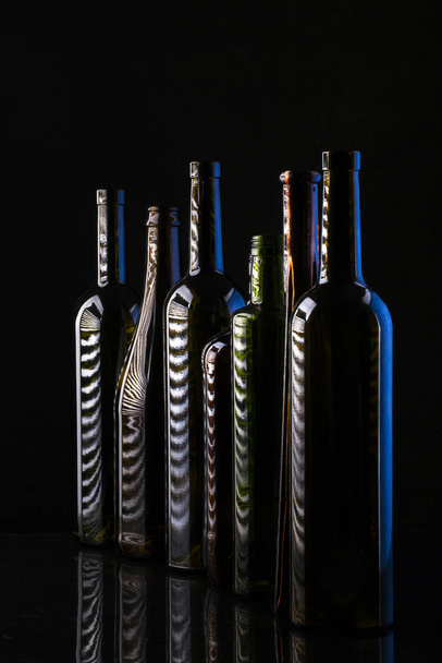 Натюрморт со стеклянными бутылками на темном фоне
 - Фото, изображение