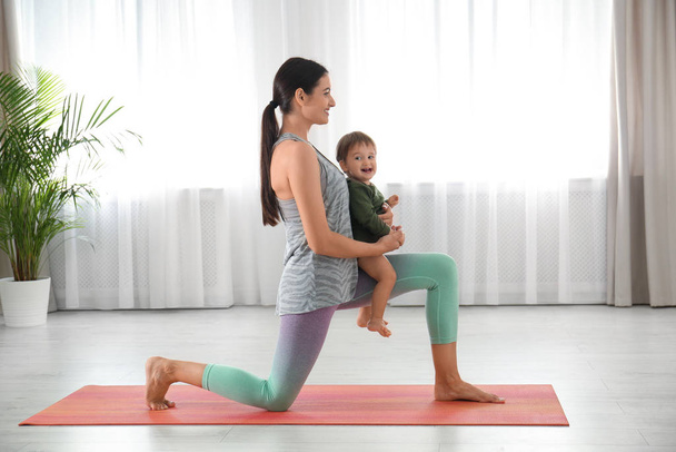 Young woman doing exercise with her son indoors. Home fitness - Φωτογραφία, εικόνα
