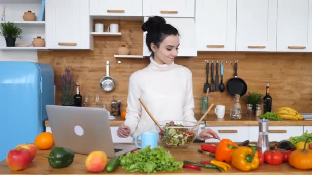 Woman Looking For A Recipe On Laptop While Cooking In Her Kitchen. - Imágenes, Vídeo