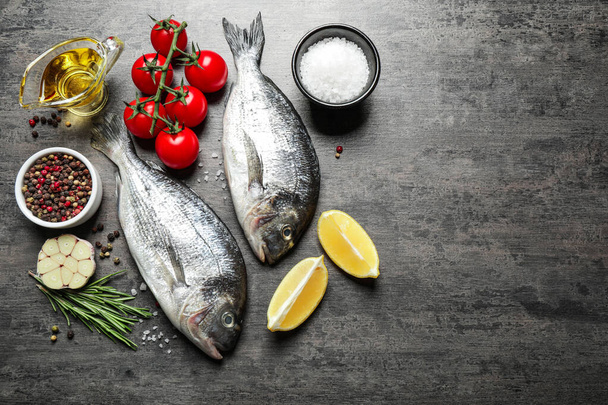 Flat lay composition with raw dorada fish on grey table - Photo, Image