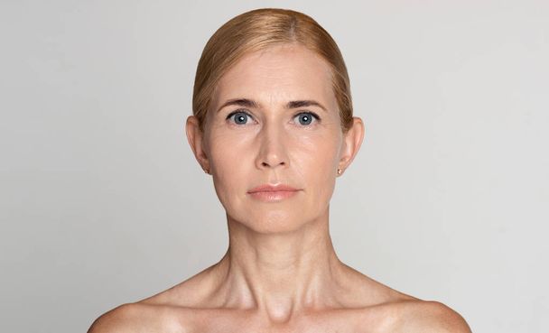 Natural beauty. Portrait of middle-aged woman, grey background - Fotoğraf, Görsel