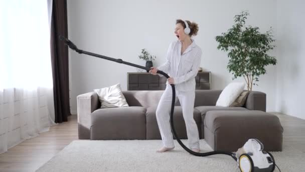Young Funny Woman Dancing With Vacuum Cleaner At Home - Záběry, video