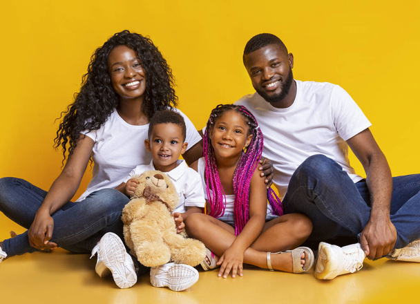 Πορτρέτο των ευτυχισμένων μαύρων γονιών με δύο μικρά παιδιά - Φωτογραφία, εικόνα