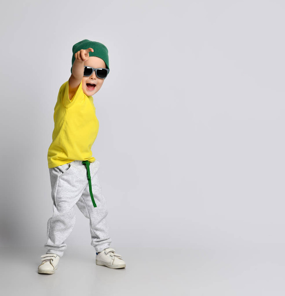 bambino ragazzo puntando un dito verso l'angolo sorridente isolato su uno sfondo bianco
 - Foto, immagini