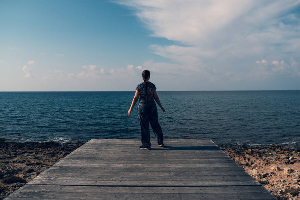 Молода красива дівчина на дерев'яному пірсі на середземному морі і блакитному фоні неба. Концепція подорожей
 - Фото, зображення