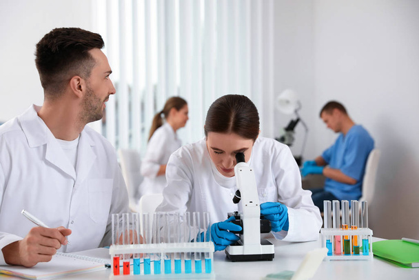 Medical students with microscope in modern laboratory - Фото, зображення