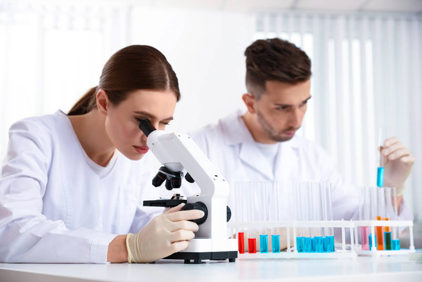 Scientist with microscope and colleague in laboratory. Medical research - Foto, Imagem