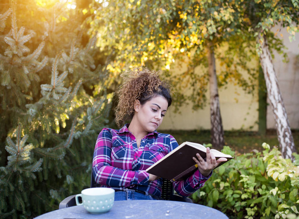 Mädchen liest Buch und trinkt Tee im Park - Foto, Bild
