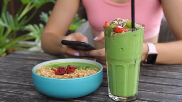 Sport Fitness Woman Using Cellphone While Having Healthy Vegan Breakfast - Séquence, vidéo