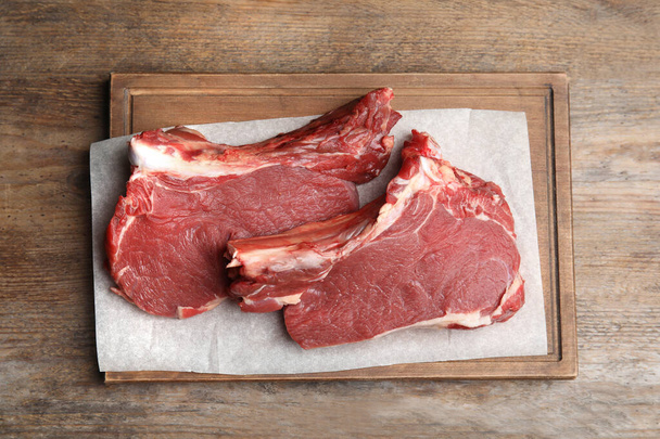 Fresh raw beef cut on wooden table, top view - Fotografie, Obrázek