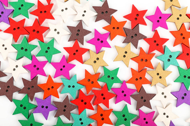 Botones de madera multicolor en forma de estrella sobre blanco
 - Foto, Imagen