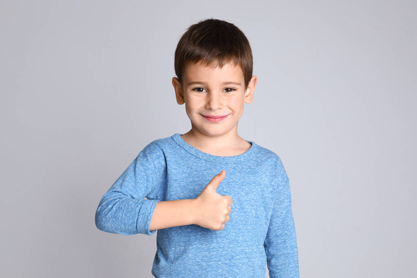 Portrait of happy little boy on light grey background - Foto, afbeelding