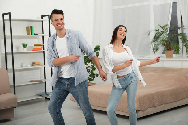 Happy young couple dancing together at home - Φωτογραφία, εικόνα
