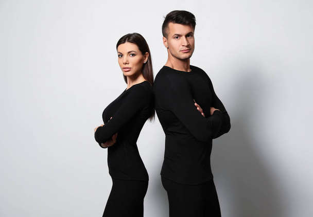 Couple wearing thermal underwear on light grey background - Zdjęcie, obraz