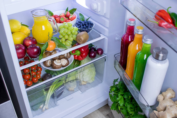 Élelmiszerfotózás friss, egészséges növényi alapú vegán ételekkel és italokkal töltött hűtőszekrényről - Fotó, kép