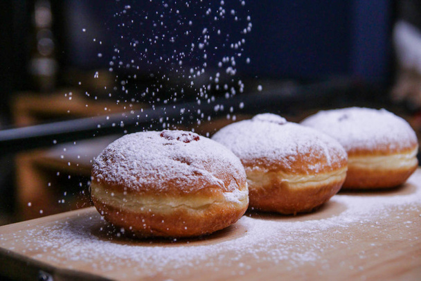 Ντόνατς με μαρμελάδα και ζάχαρη σε σκόνη με φόντο μπούκεχ. Εβραϊκή γιορτή Χάνουκα έννοια και φόντο. Αντιγραφή χώρου για κείμενο. Ρηχό Dof - Φωτογραφία, εικόνα