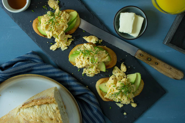 Voedselfotografie van avocado toast met roerei en andere ontbijtartikelen - Foto, afbeelding