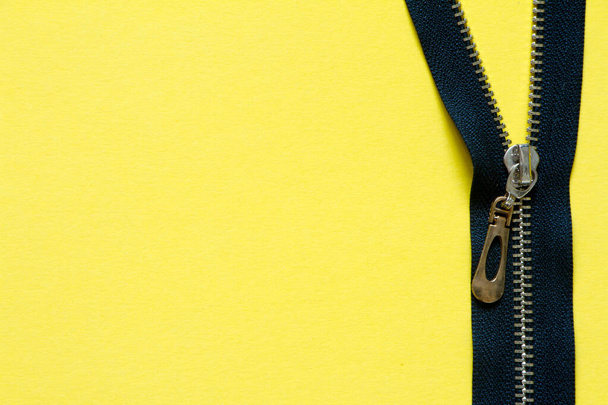 Open zipper clasp with a golden slider on a yellow background, minimalistic background or concept - Photo, Image