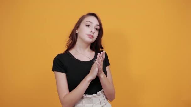 Serious young woman in black shirt claps her hands, happy - Filmagem, Vídeo