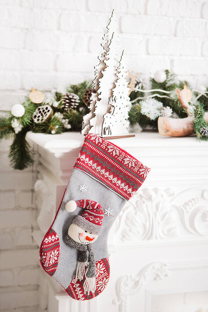 Piękna skarpeta świąteczna z prezentami na kominku - Zdjęcie, obraz