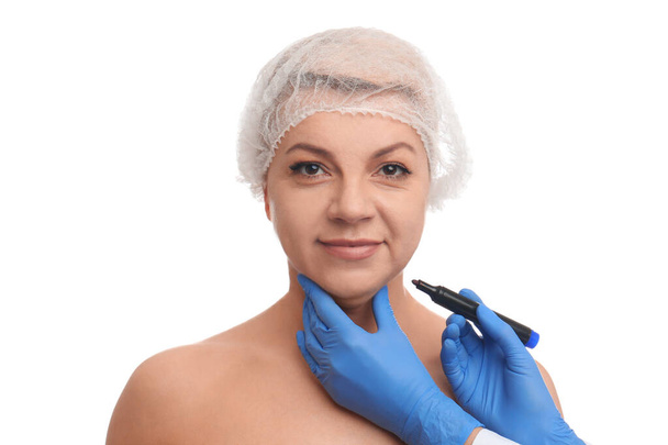 Chirurg z markerem przygotowującym kobietę do operacji przeciwko białemu  - Zdjęcie, obraz