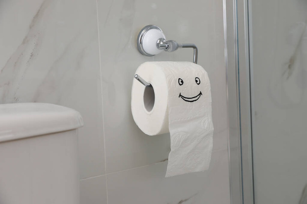 Paper with drawn funny face near toilet tank in bathroom - Φωτογραφία, εικόνα