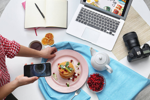 Food blogger taking photo of her breakfast at table, top view - Fotografie, Obrázek