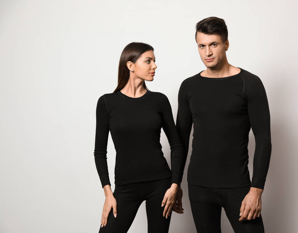 Couple wearing thermal underwear on light grey background - Fotografie, Obrázek