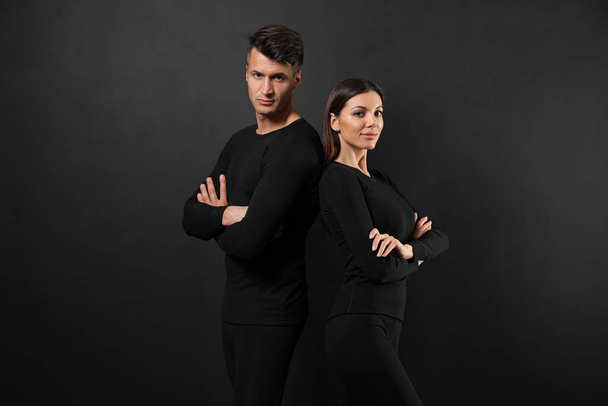 Couple wearing thermal underwear on black background - Photo, image