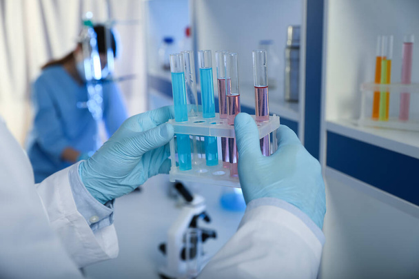 Scientist holding test tubes with liquid indoors, closeup. Laboratory analysis - Foto, Imagen
