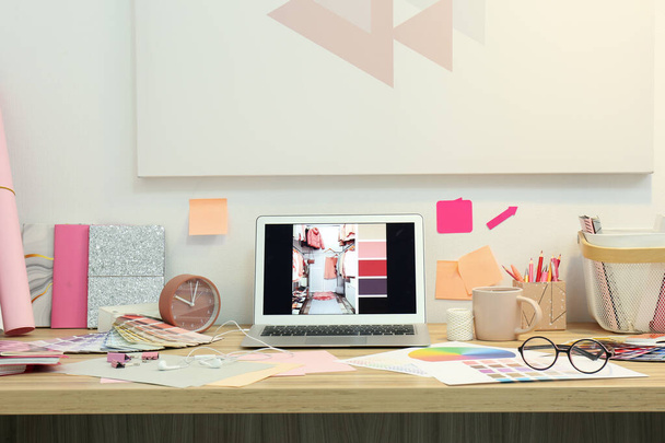 Χώρος εργασίας σχεδιαστών με σύγχρονο laptop και χρωματικές παλέτες  - Φωτογραφία, εικόνα