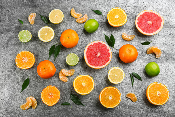 Flat lay composition with tangerines and different citrus fruits on grey background - Φωτογραφία, εικόνα
