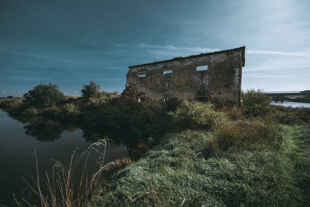Dilapidada casa abandonada y estanque
 - Foto, Imagen