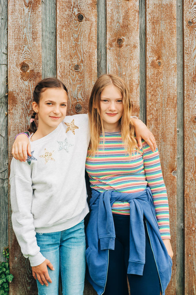 Nuori preteen 10-12-vuotiaat tytöt poseeraavat yhdessä ulkona
 - Valokuva, kuva